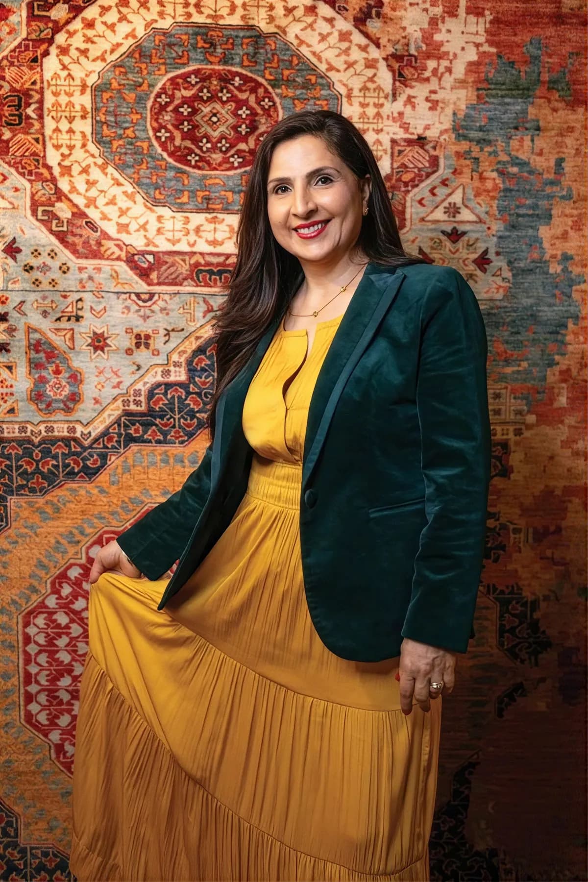 Arifa Akbari, founder, in front of a hand-knotted rug